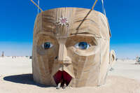 man swallow by giant head Black Rock City, Neveda, USA, North America